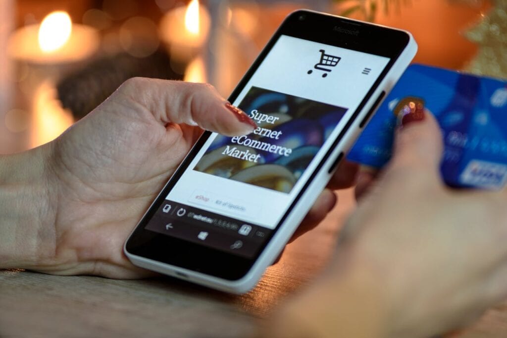 person-using-black-and-white-smartphone-and-holding-blue-card-230544 Person Using Black And White Smartphone and Holding Blue Card
