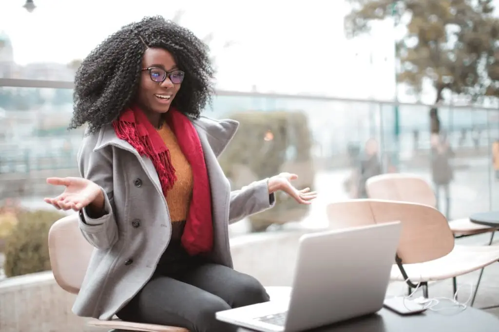 cheerful-surprised-woman-sitting-with-laptop-3762940 Happy excited African American female laughing and gesticulating while having video calling on laptop and sitting at modern cafe