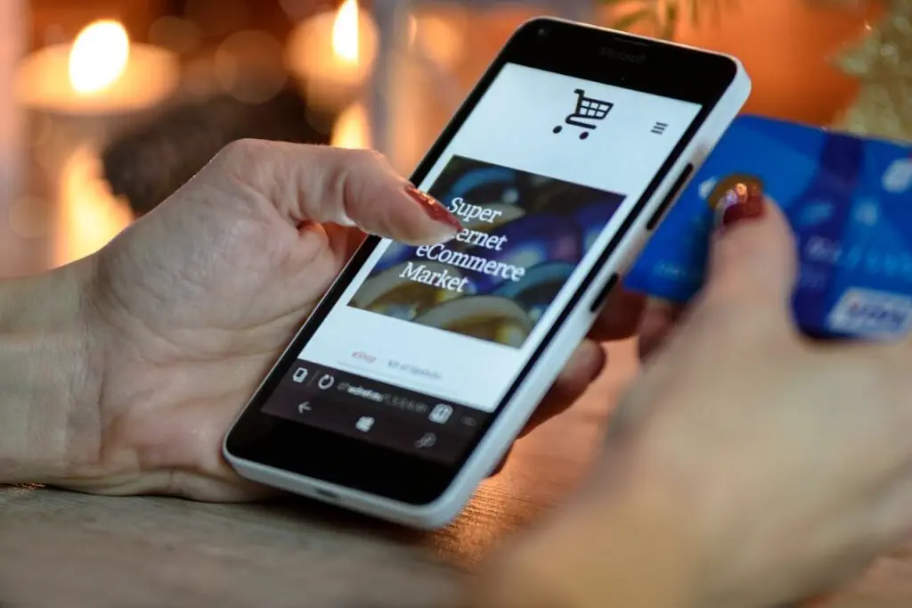 person-using-black-and-white-smartphone-and-holding-blue-card-230544 Person Using Black And White Smartphone and Holding Blue Card